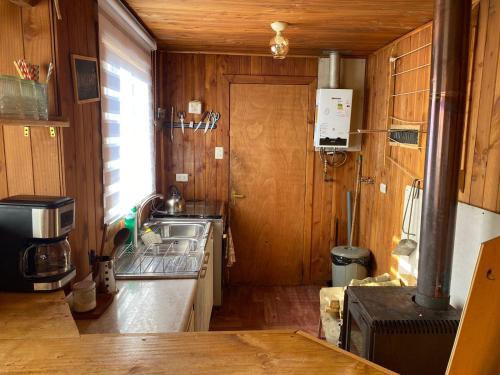 a small kitchen with a sink and a stove at Cabañas Doña Norma in Puyehue