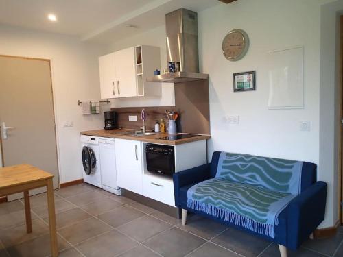 une cuisine avec une chaise bleue et un évier dans l'établissement Une fenêtre à la campagne, à Saint-Désir
