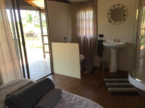 a bathroom with a sink and a toilet and a mirror at Klein Paradys Lodge - Polokwane in Polokwane