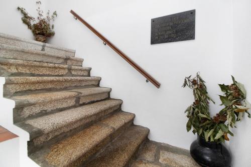 a staircase with a plant and a sign on the wall at Casa do Adro do Soajo in Soajo