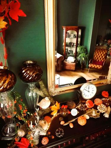 a table with a mirror and a clock on it at B&B La Sucrerie in Amougies