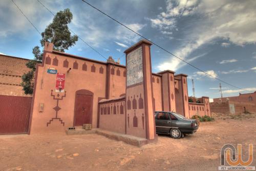 a building with a car parked in front of it at Kasbah tifaoute ait Ben haddou in Aït Ben Haddou