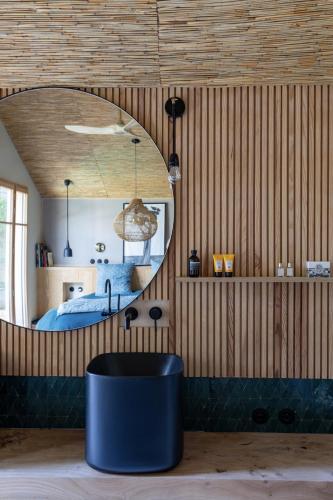 - une chambre avec un lit et un miroir rond dans l'établissement Maison d architecte contemporaine la pierre blanche, à Bordeaux