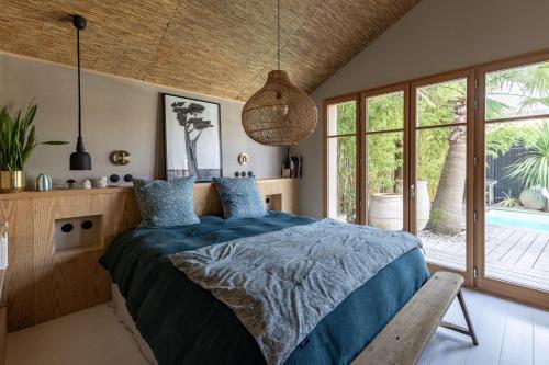 une chambre avec un lit et une grande fenêtre dans l'établissement Maison d architecte contemporaine la pierre blanche, à Bordeaux
