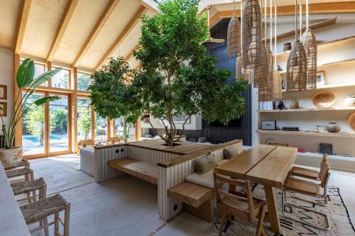 una sala da pranzo con tavolo e albero di Maison d architecte contemporaine la pierre blanche a Bordeaux