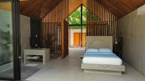 ein Schlafzimmer mit einem Bett in der Mitte eines Zimmers in der Unterkunft Karang Villas Uluwatu in Uluwatu