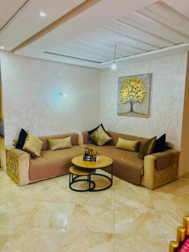 a living room with a couch and a table at superbe appartement en résidence balnéaire in Bouznika