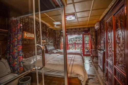 a bedroom with two beds in a room with ornate walls at LQJ Riverside Guest House in Fenghuang