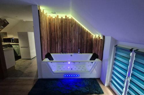 a bathroom with a bath tub in a room at Balnéo Nuits Douces Rouen in Rouen
