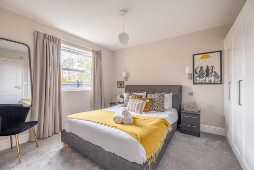 a bedroom with a large bed with a yellow blanket at Modern 2 Bed Oasis - Private parking & Garden in Windsor