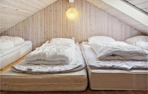 two beds in a room with a wall at Awesome Home In Dannemare With Sauna in Dannemare