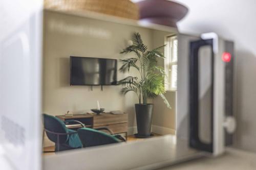 a living room with a potted plant in a room at Modern 2 Bed Oasis - Private parking & Garden - By Tempstay in Windsor