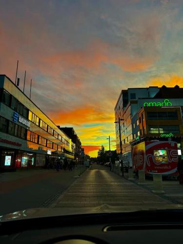 an empty city street with a sunset in the background at Viihtyisä asunto ydinkeskustassa in Seinäjoki