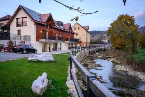 a house and a fence next to a river at Hiša Janko in Dolenjske Toplice