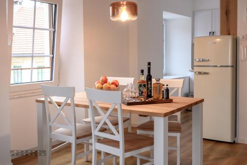 a kitchen with a table with a bowl of fruit and a refrigerator at Hiša Janko in Dolenjske Toplice