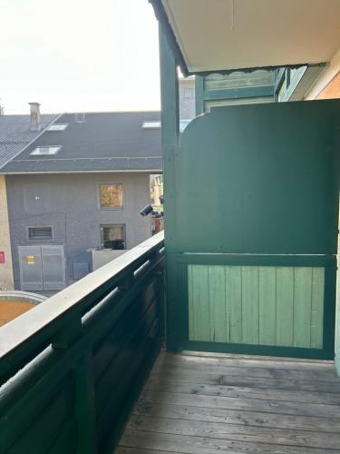 a green door on a balcony with a building at Hotel Berg in Seekirchen am Wallersee