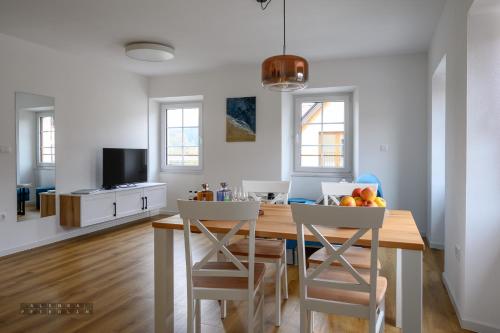 a kitchen and dining room with a wooden table and chairs at Hiša Janko in Dolenjske Toplice