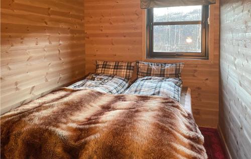 a bed in the corner of a room with wooden walls at Lovely Home In Vikeså With Kitchen in Vikeså