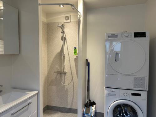 a bathroom with a shower and a washing machine at 11A Højbanetorvet in Vejle