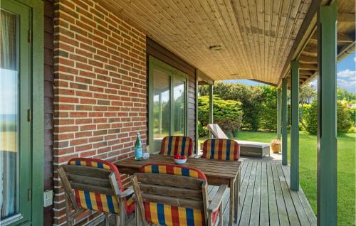 a porch with two chairs and a wooden table at Stunning Home In Allingåbro With Wifi in Allingåbro