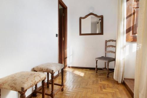 a hallway with two chairs and a mirror on the wall at Casa do Adro do Soajo in Soajo