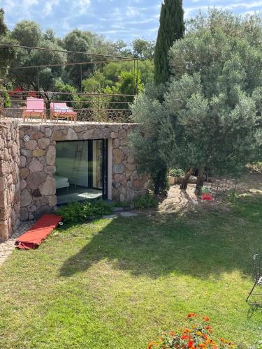 - un bâtiment en pierre avec une fenêtre dans une cour dans l'établissement Lavezzi - 2 bedrooms & swimming pool - beach 5min, à Zonza