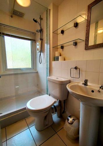 a bathroom with a toilet and a sink and a tub at Woodland View - Families & Pets in Uny Lelant