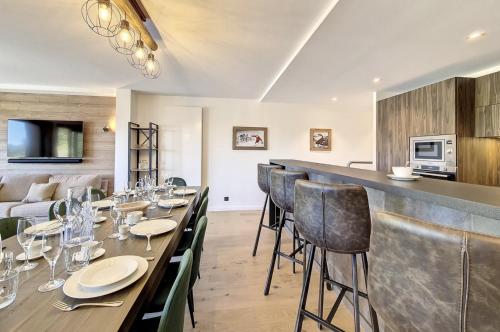 une salle à manger avec une longue table et des chaises dans l'établissement Les Chalets A11 Meribel, spacious family duplex, 100m from ski lift Les Chalets, à Méribel