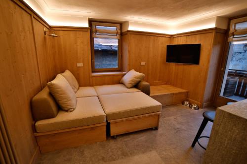 a small living room with a couch and a tv at Bormio Cozy Gem in Bormio