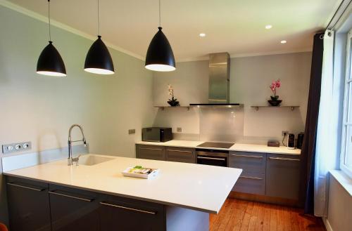 cocina con encimera blanca y electrodomésticos negros en Petit Bengale, en Talence