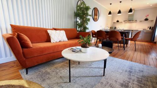 Una sala de estar con un sofá naranja y una mesa. en Petit Bengale, en Talence