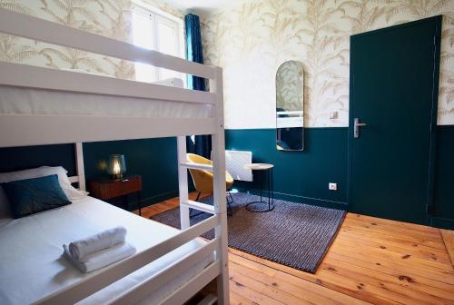 une chambre avec un lit superposé et un bureau dans l'établissement Petit Bengale, à Talence