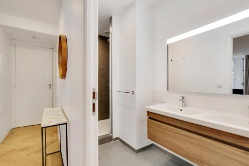 une salle de bain blanche avec un lavabo et un miroir dans l'établissement Pick A Flat's Apartments in Saint Michel - Rue Du Sommerard, à Paris