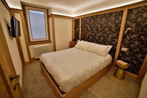 a small bedroom with a bed and a window at Bormio Cozy Gem in Bormio