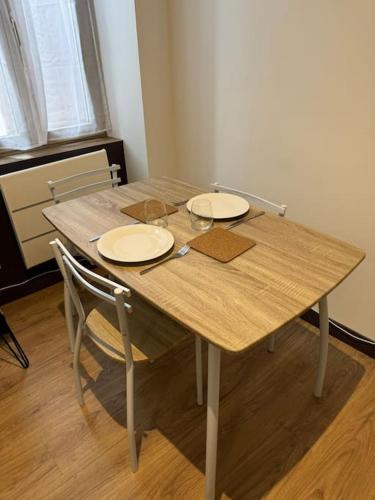 une table en bois avec deux plaques au-dessus dans l'établissement Cosy studio Tournons, à Tournon-sur-Rhône