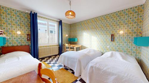 une chambre avec deux lits et une fenêtre dans l'établissement Villa le Bercail, à Saint-Gilles-Croix-de-Vie