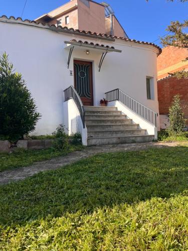 a white house with stairs and a door at Casa Rural Can Bastida in Cardona