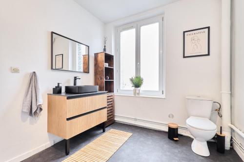 une salle de bain avec toilettes, lavabo et miroir dans l'établissement Le Cocon, Centre-ville, Calme, 4 personnes, Proche commerces, à Reims