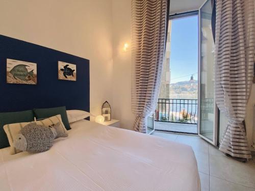 a bedroom with a large bed and a large window at Alla Casa Rosa al Mare, Central Seafront Stay, Air Conditioning, Wi-Fi, the Ideal Choice for a Relaxing and Exciting Coastal Escape, with available on request at 20,00 euro per night Private Garage, Welcome kit Priority, Prosecco and Canestrelli in Rapallo