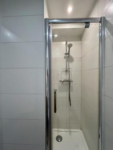 une douche avec une porte vitrée dans une salle de bain dans l'établissement Fully equipped Studio near metro, à Paris
