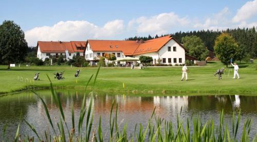 a group of people playing golf next to a pond at Hotel Goldene Sonne in Landshut