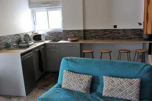 une cuisine avec un canapé bleu dans l'établissement O coeur du medoc, à Saint-Julien-Beychevelle