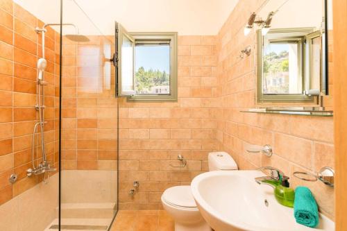 a bathroom with a toilet and a sink and a shower at Villa Andrea by Villa Plus in Lourdhata
