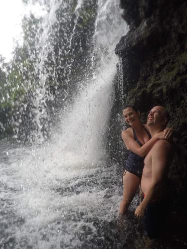 two people standing in front of a waterfall at Budget Hack Maui SUV camping in Kahului