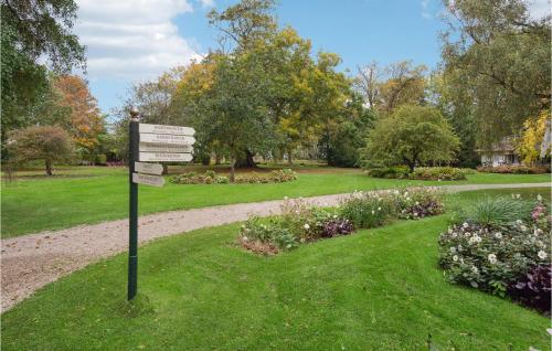 a sign in the middle of a park with flowers at Gorgeous Home In Næstved in Næstved
