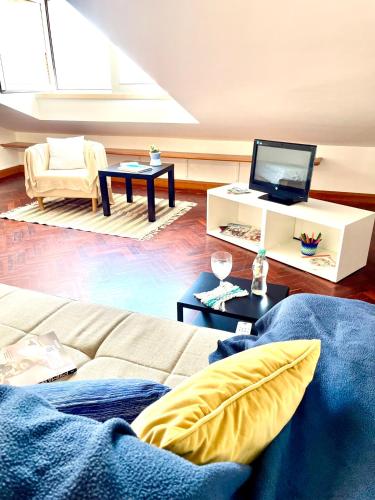 a living room with a couch and a tv at Cozy Carcavelos Beach-NOVA SBE in Carcavelos