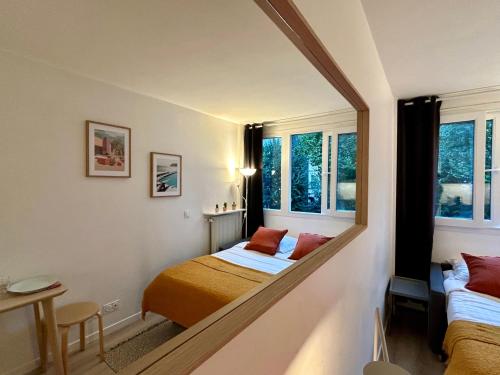 une petite chambre avec deux lits et un miroir dans l'établissement Fully equipped Studio near metro, à Paris
