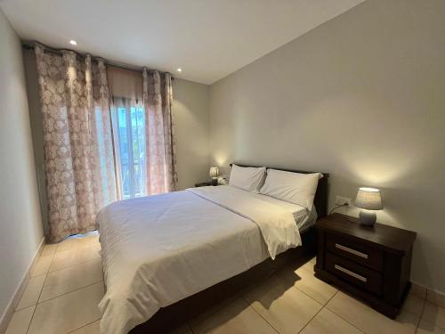 a bedroom with a large bed and a window at Forest View Apartments in Kololi