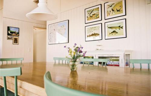 a dining room with a table and a vase of flowers at Three-Bedroom Holiday Home In Allingabro in Rygård Strand