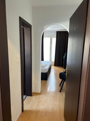 a room with a bed and a room with a door at Hotel Berg in Seekirchen am Wallersee